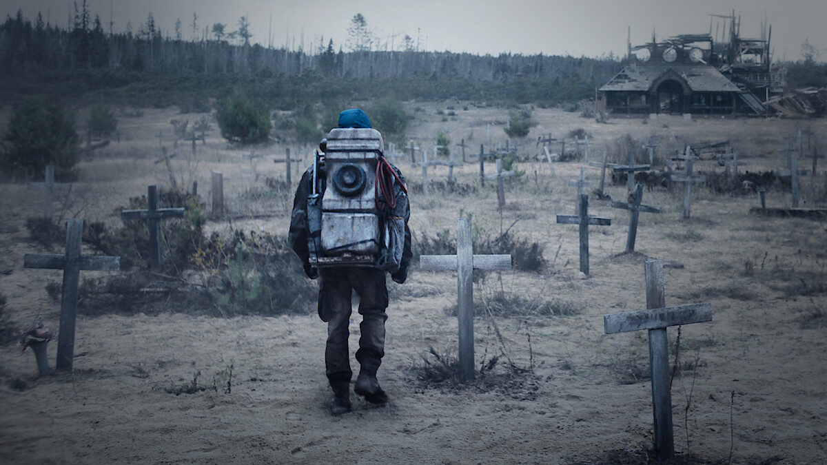 شخصیتی با کوله‌پشتی در یک قبرستان متروکه در سریال تاریک، نمادی از سفر در زمان و تاریخ پیچیده سریال.