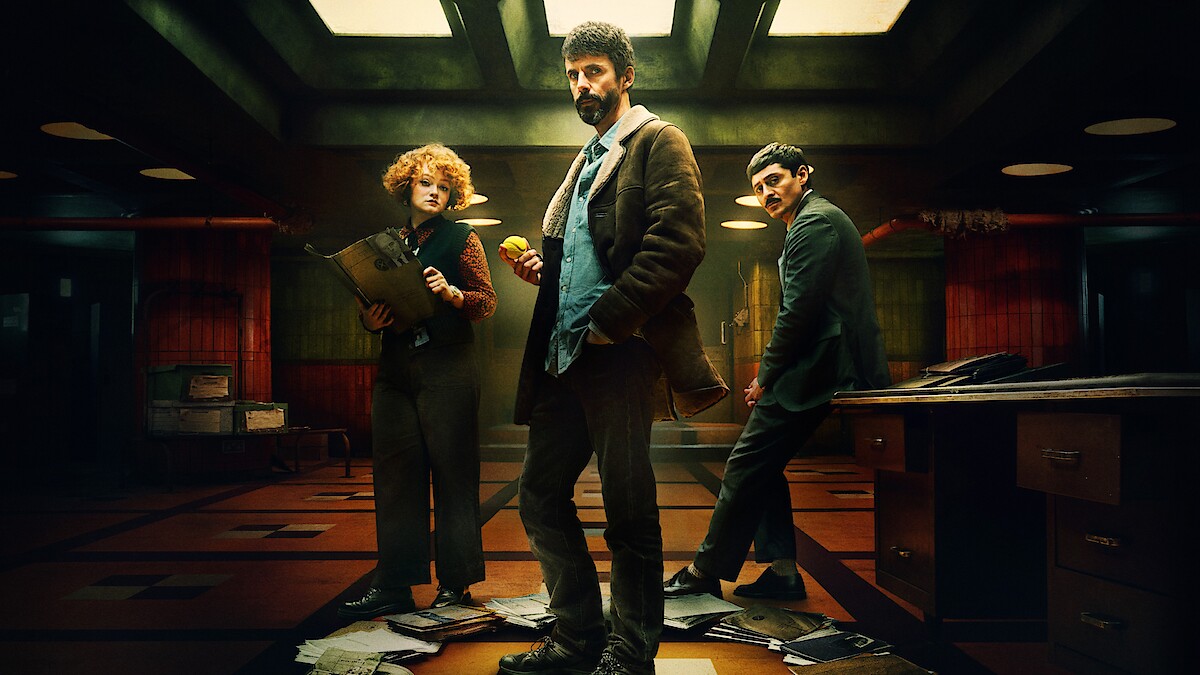 سه عضو اصلی دپارتمان کیو در دفتر کار تاریک خود در حال بررسی یک پرونده هستند.