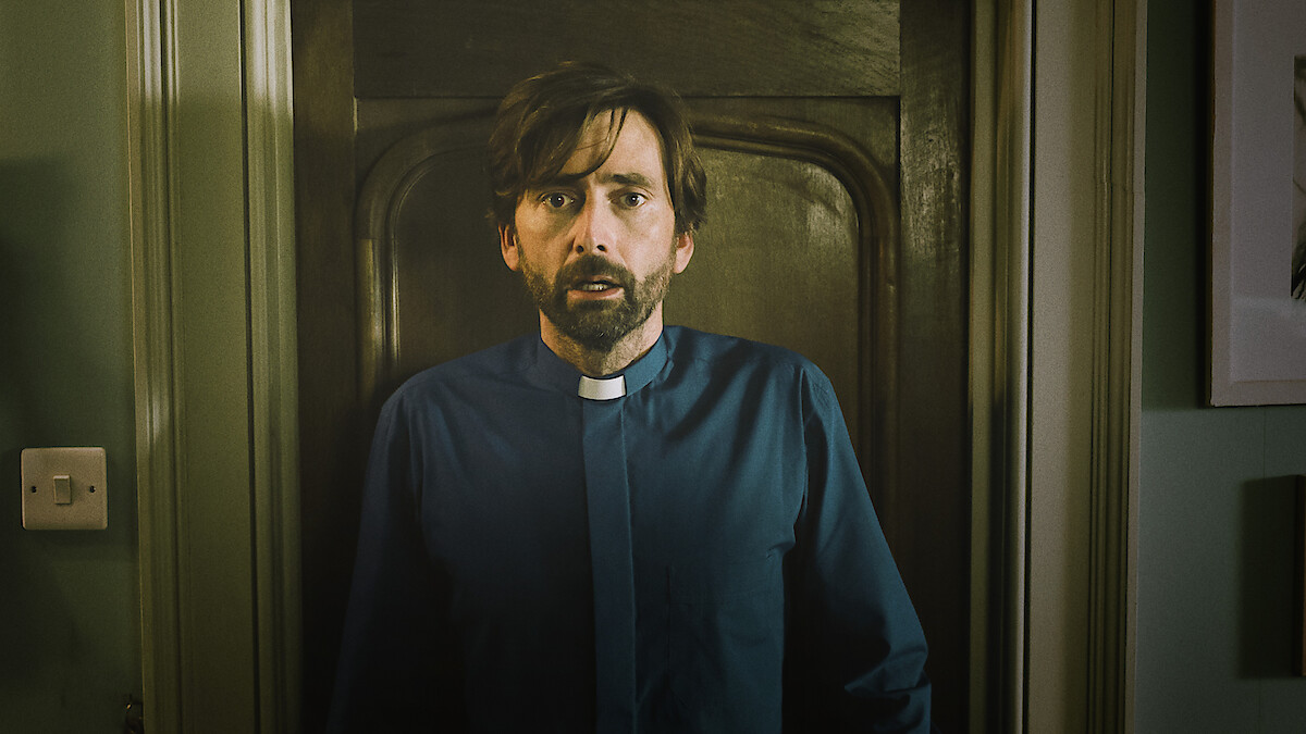 دیوید تننت در نقش کشیش هری واتلینگ در سریال اینساید من با چهره‌ای مضطرب.