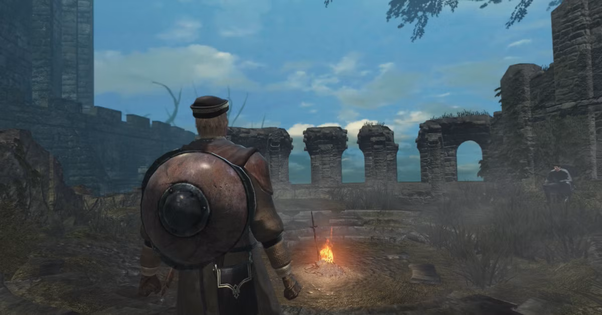 شخصیت بازی Dark Souls در حال استراحت کنار آتش در منطقه Firelink Shrine.